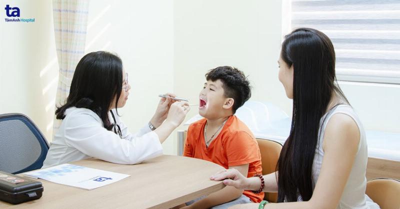 Bác sĩ khám và lấy mẫu phết họng để chẩn đoán nguyên nhân đau họng